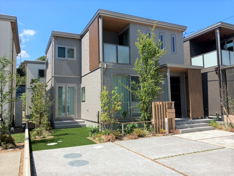 「グレイッシュモダンの住まい」 ― 淡いグレージュに包まれた空間が日々を穏やかに整え、一面に貼られたタイル調クロスがリビングにさりげない個性を添える。屋根付きのサービスヤードが室内をスッキリ保つことにも貢献します。