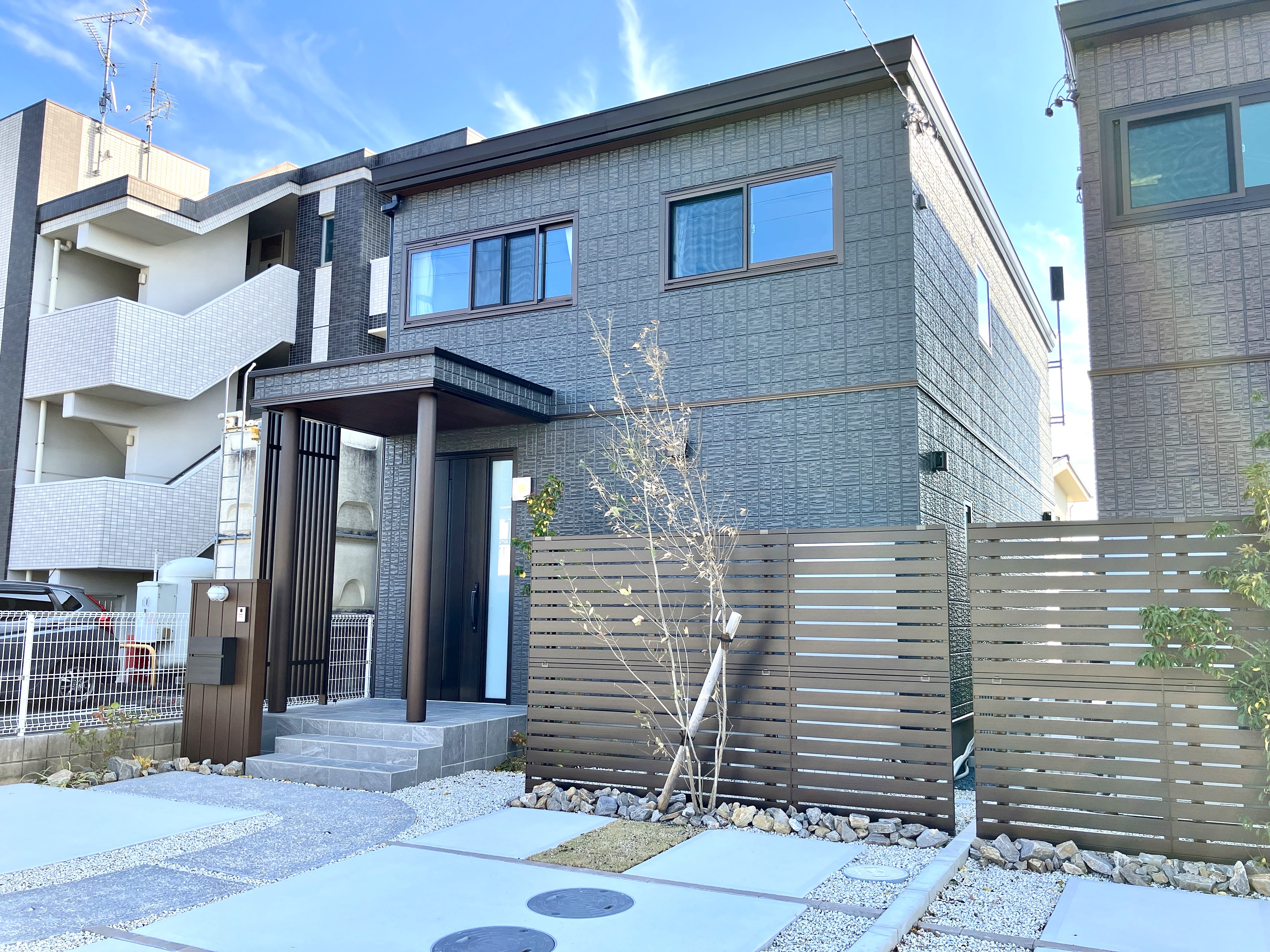 「モノトーンスタイルの家」  ― ホワイトアッシュの床とモノトーンで整えられた室内が、洗練と静けさを描く。二列型キッチンは調理と動線をすっきり分け、南に開かれたプライベートガーデンへもゆるやかにつながる。