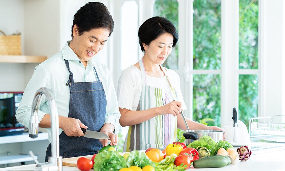 色とりどりの野菜で料理をする男性と女性