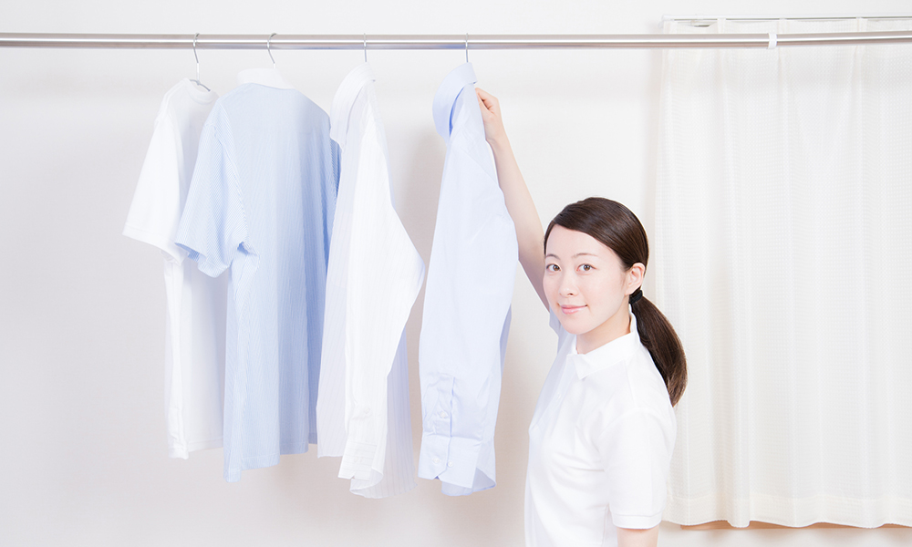 服を干しながらこっちを向く女性